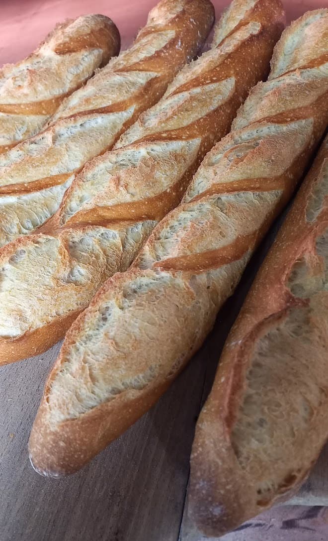 Baguettes tradition dorées et croustillantes alignées sur une planche en bois